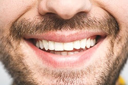 Close up of man’s smile with stubbled beard