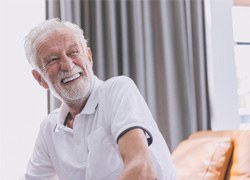 Senior man sitting on a couch and smiling