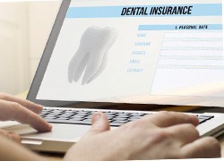 Close-up of filling out dental insurance form on a laptop