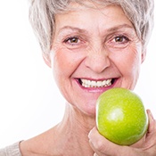 Senior woman eating apple