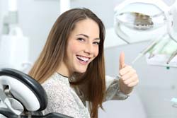 Woman giving thumbs-up while visiting Syracuse general dentist