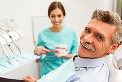 Older man smiling with implant dentures in Syracuse