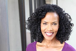 Woman in purple shirt smiling with beautiful teeth