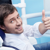 Man in dental chair giving thumbs up