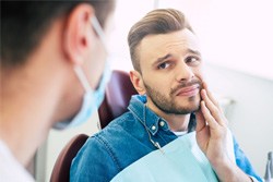 man looking in pain at the dentist 