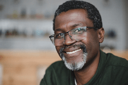 MBearded man with glasses smiling with veneers in Syracuse, NY