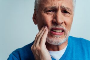 older man experiencing mouth pain