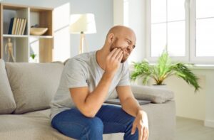 man holding his face with tooth pain