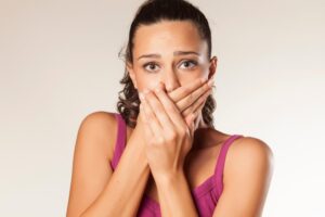 embarrassed woman covering her mouth